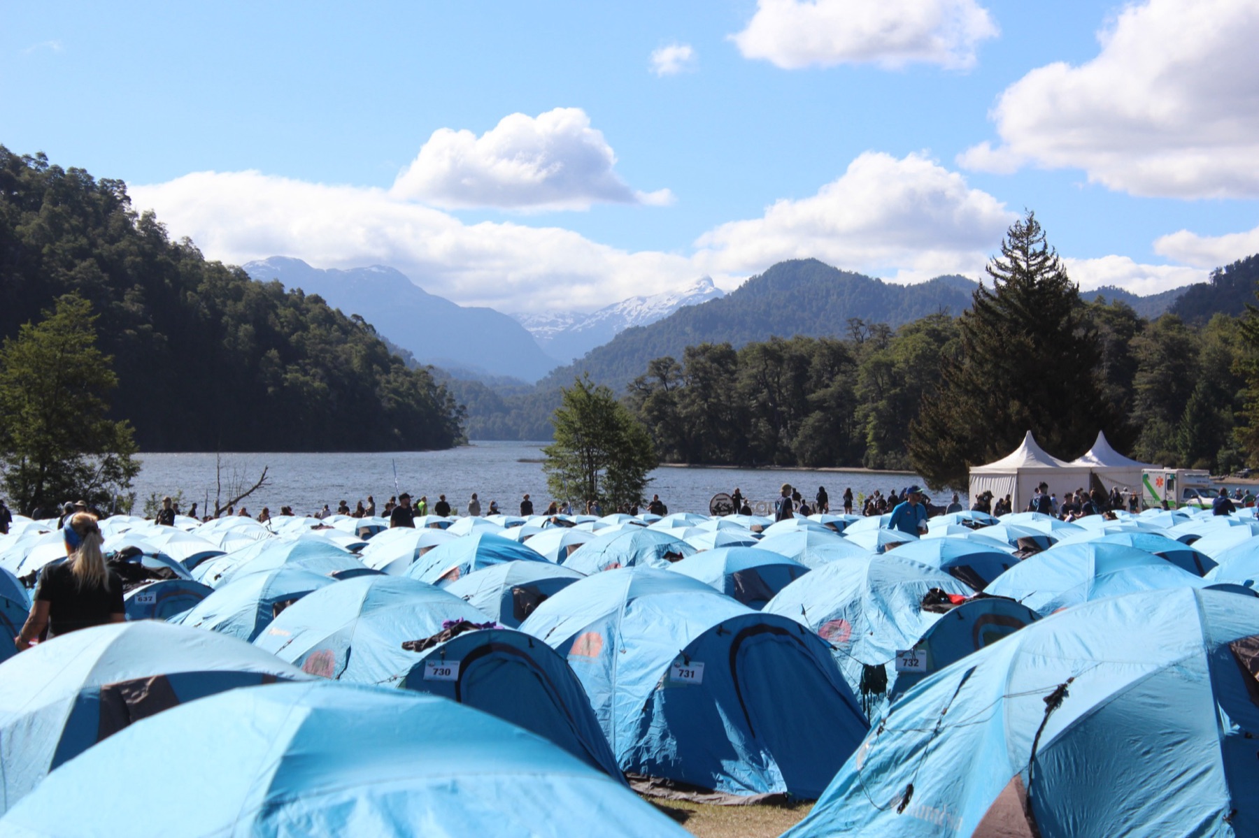 Carpas azules del campamento frente al lago y las montañas