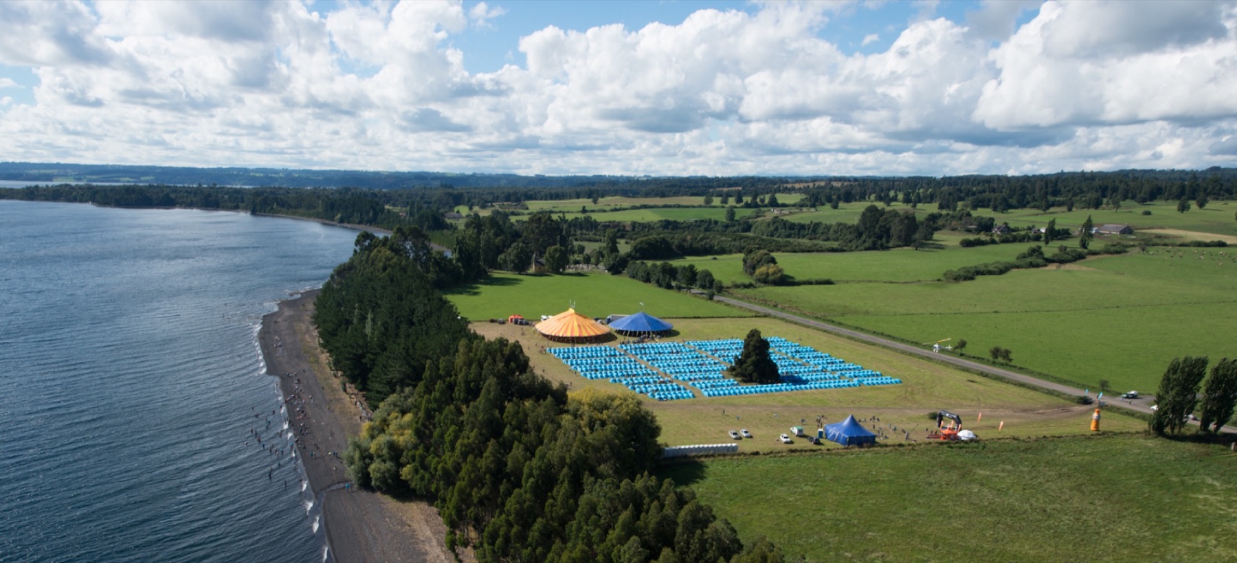 Vista aérea de un campamento de El Cruce entre el lago, el bosque y los campos