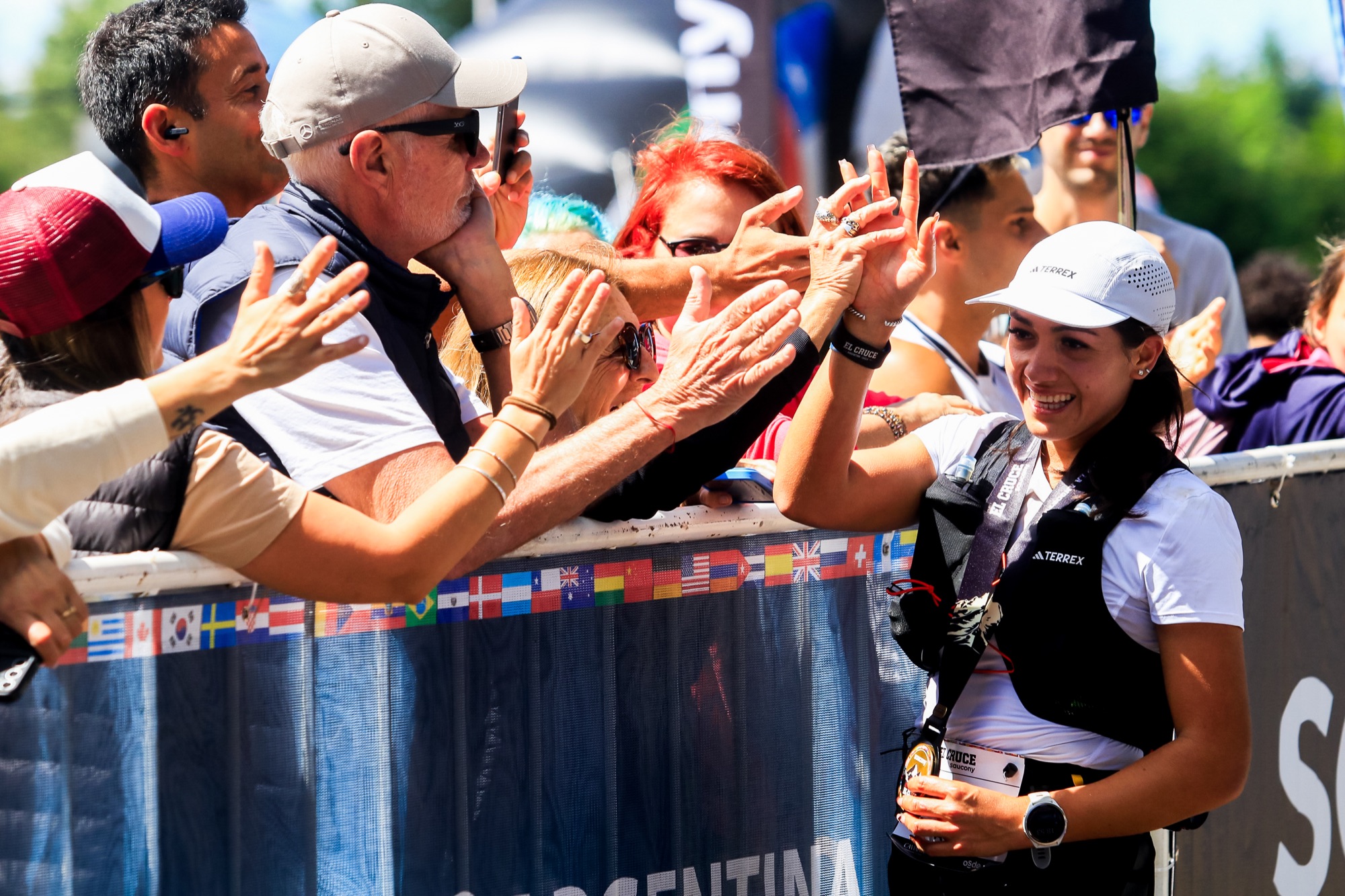 The crowd cheers and high-fives a runner at the finish
