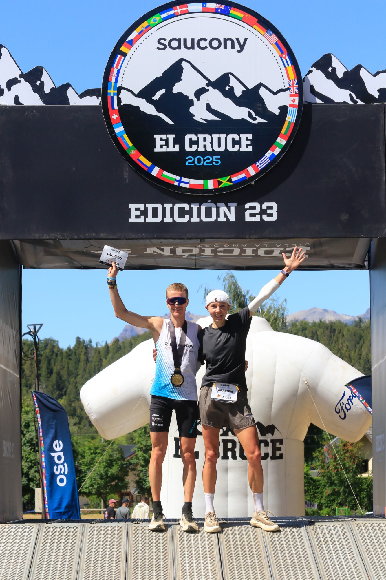 Dos corredores celebran bajo el arco de llegada de El Cruce