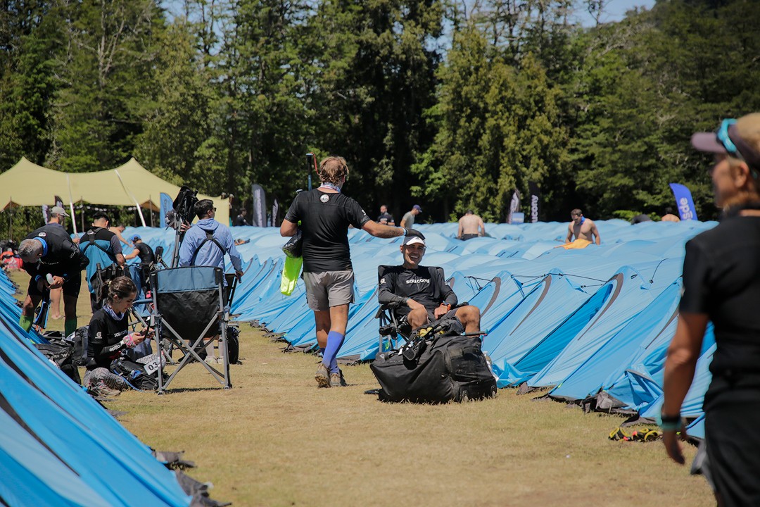 Corredores descansan entre las carpas del campamento